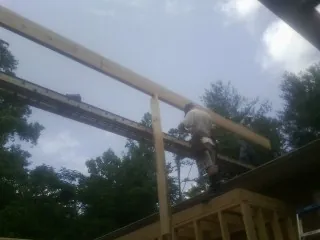 Carpenter setting a ridge beam over a new addition frame — Ice Dam Removal by Roofing Brothers in Sisseton