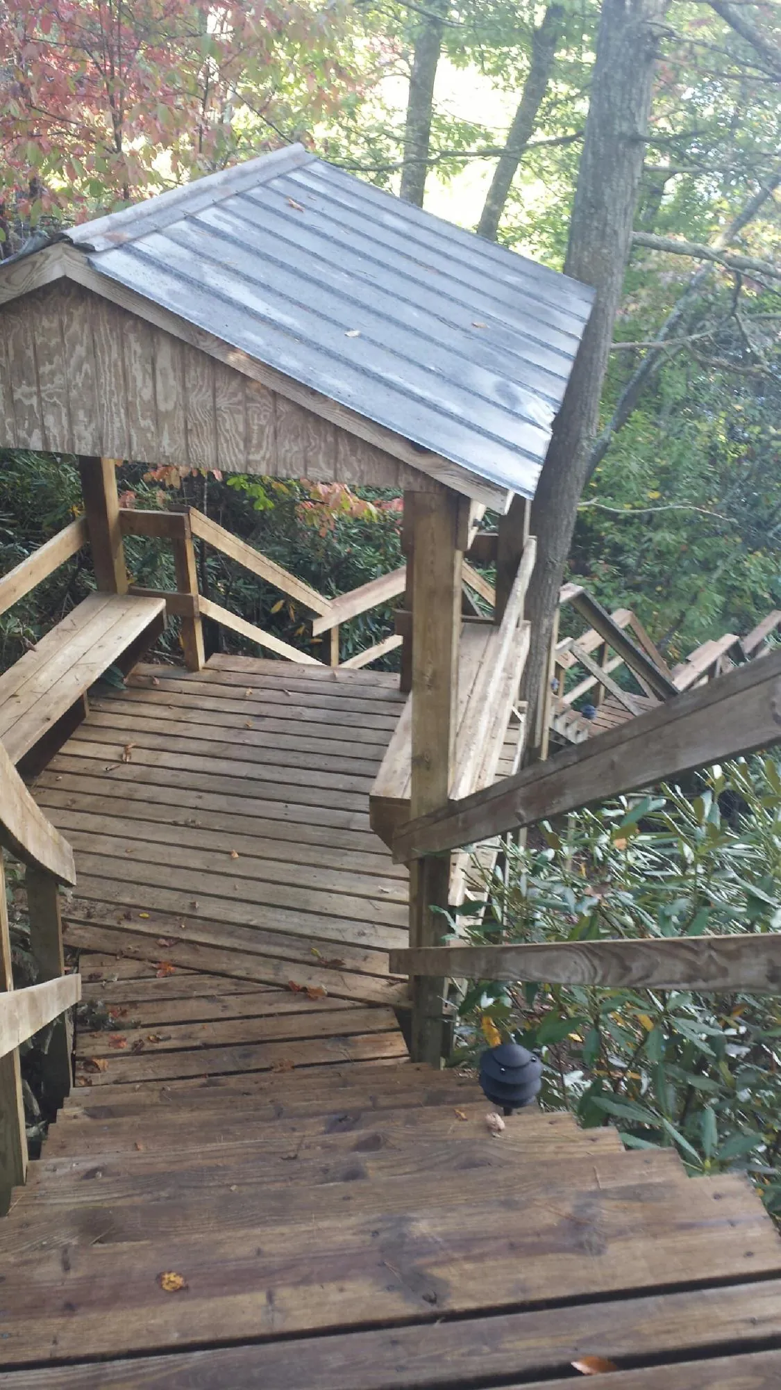 Metal roofed shelter over wooden steps on a wooded walkway — Skylight Repair & Installation work by our crew in Sisseton